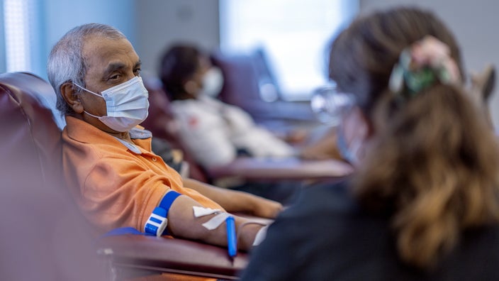 An older adult is getting blood drawn at a clinic.