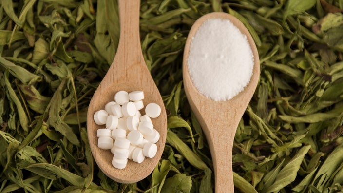 Spoonfuls of stevia sweetener lie on top of a bed of stevia leaves. Stevia is a sugar substitute recommended for people with diabetes, but some stevia products can raise blood glucose levels.