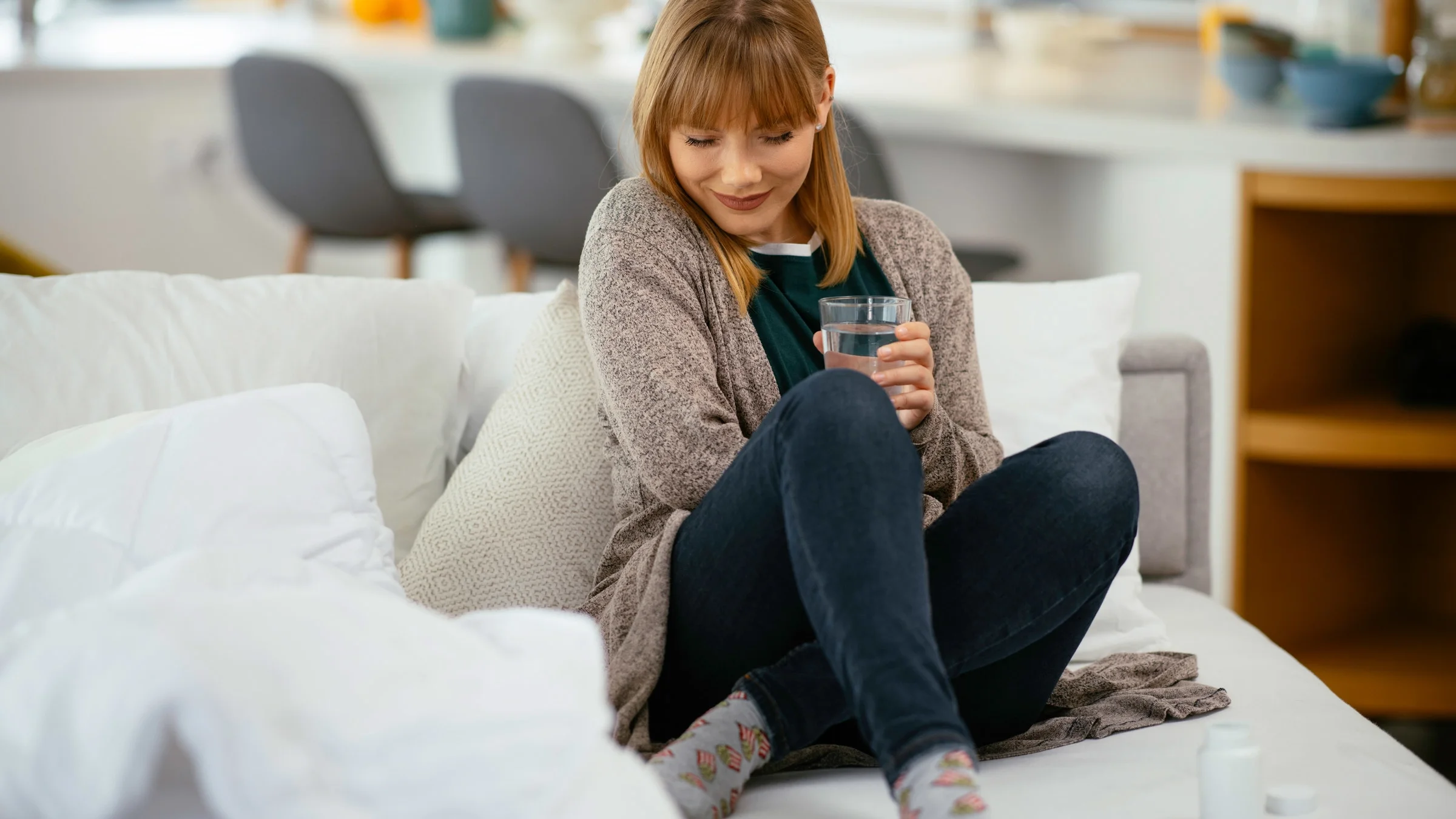 A person with a stomachache drinking water.