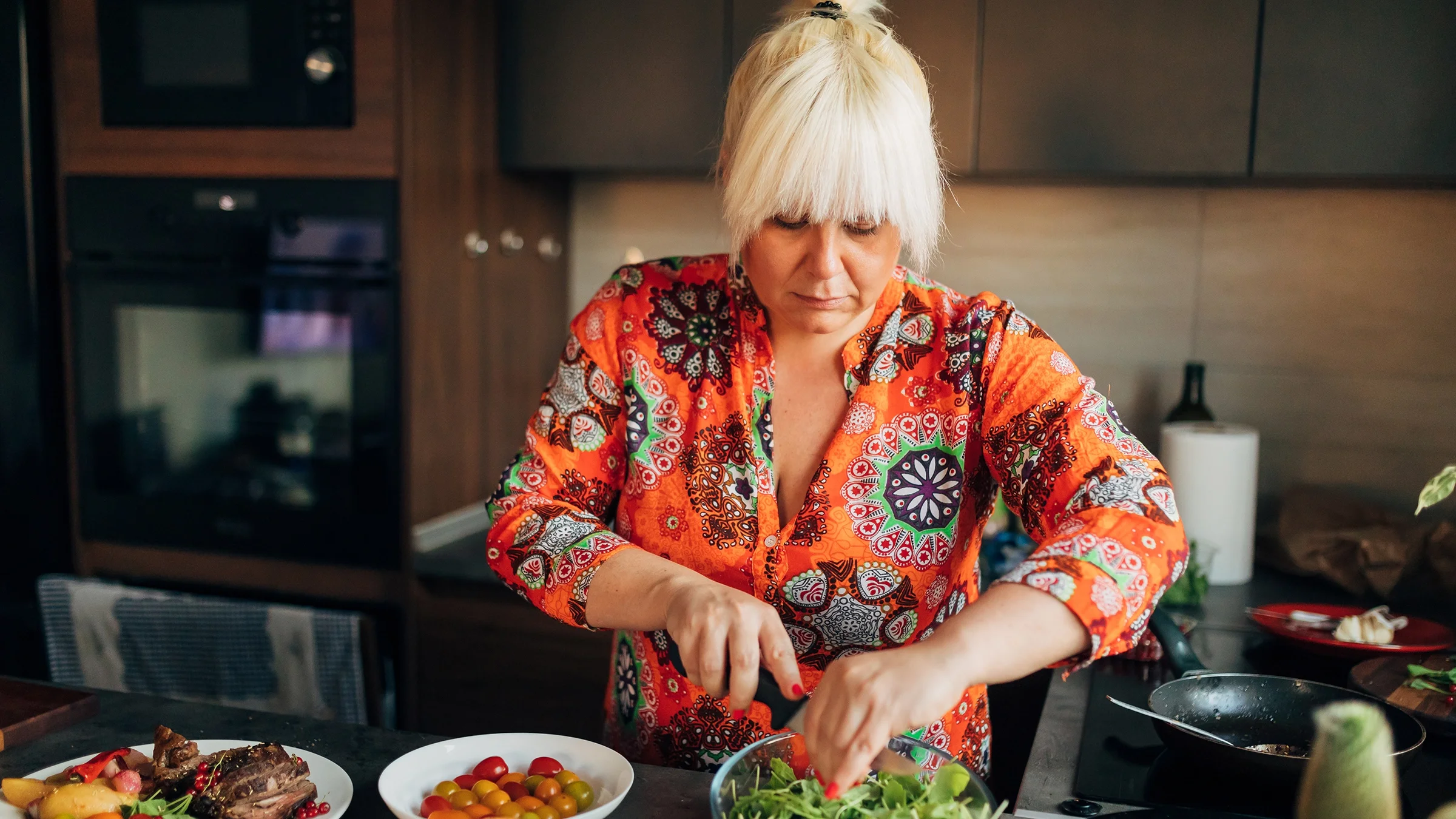 Woman preparing a salad at home.
