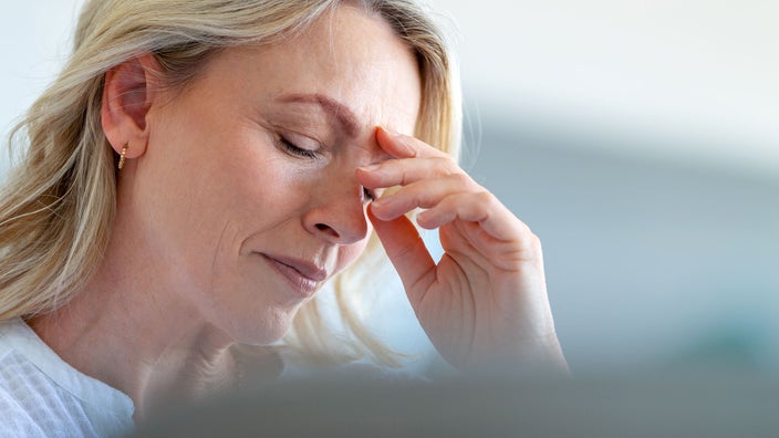 Woman feeling faint with hand on her forehead