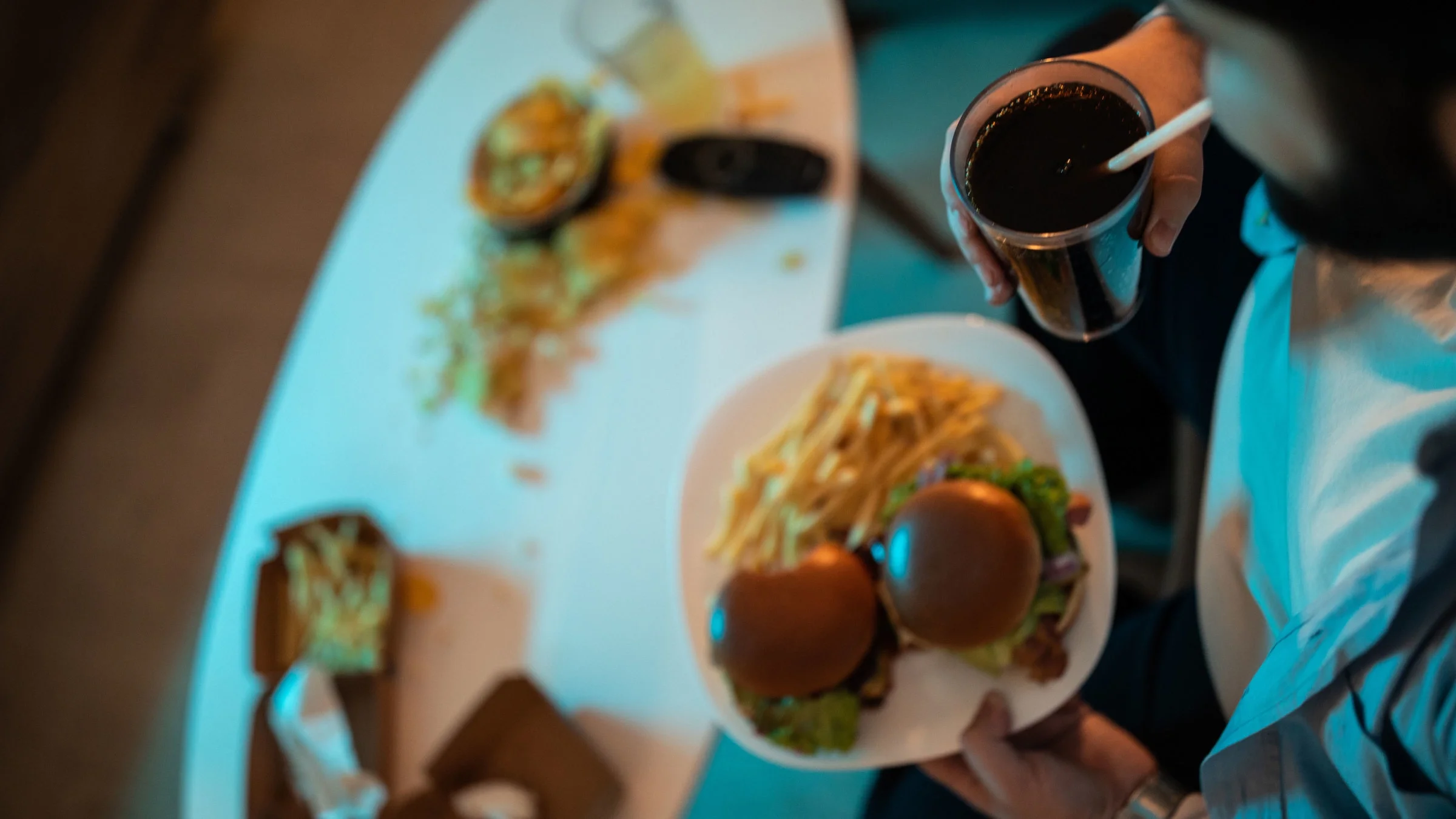 Close up of man eating cheeseburgers and french fries.
