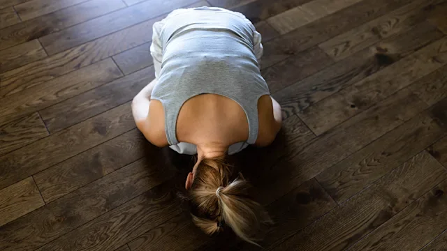 vertigo: woman bending forward exercise with head on floor 1539044884