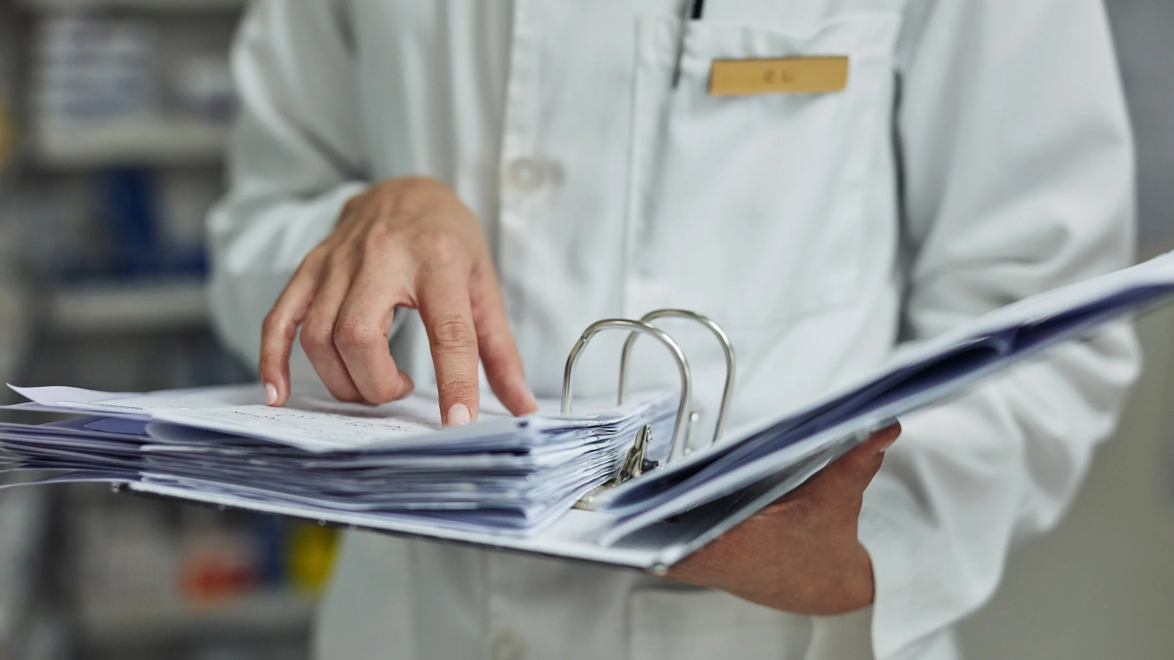 A pharmacist holding a binder.
