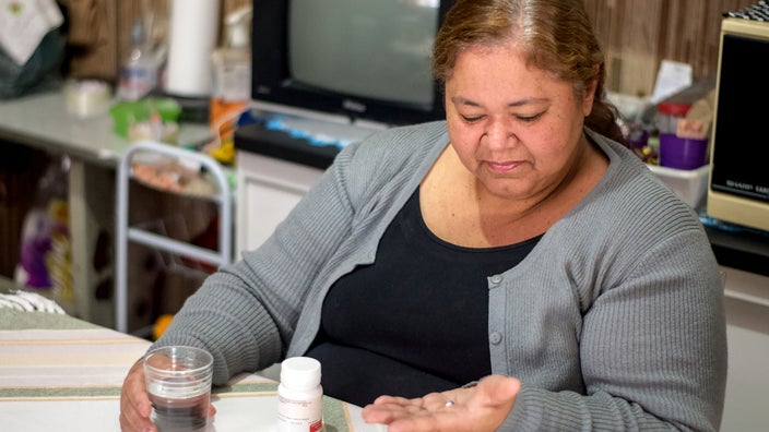 Woman taking oral medication at home.