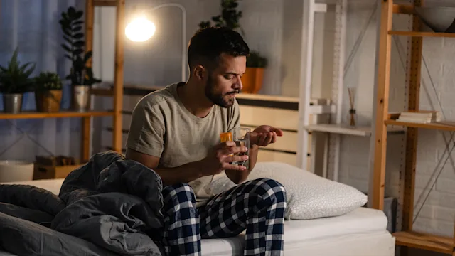 ED: man taking medication in bed 1739493168