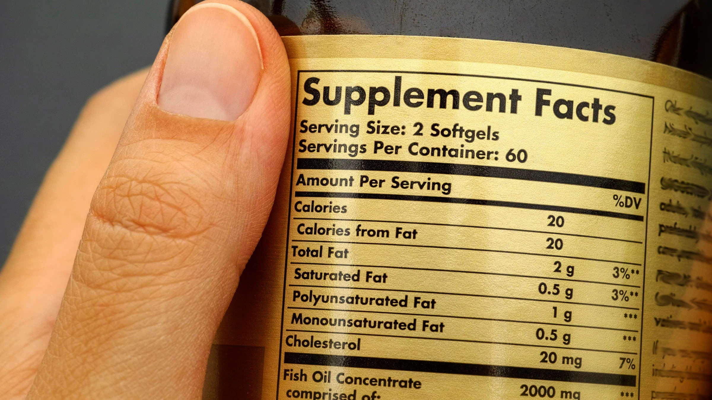 A person holds a bottle of supplements. Research on whether multivitamins are good for you is mixed.