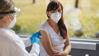 older woman getting COVID vaccine-1299863411