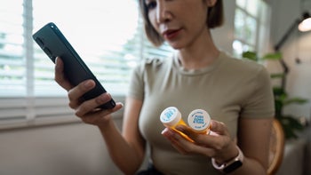 side-effects: closeup holding medication and smartphone 2162508473