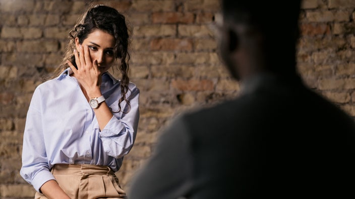 A client wiping tears in an emotional therapy session.