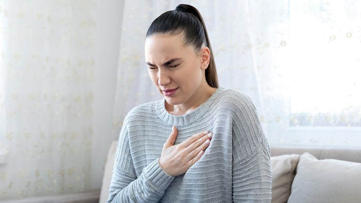 A woman struggles with heartburn.