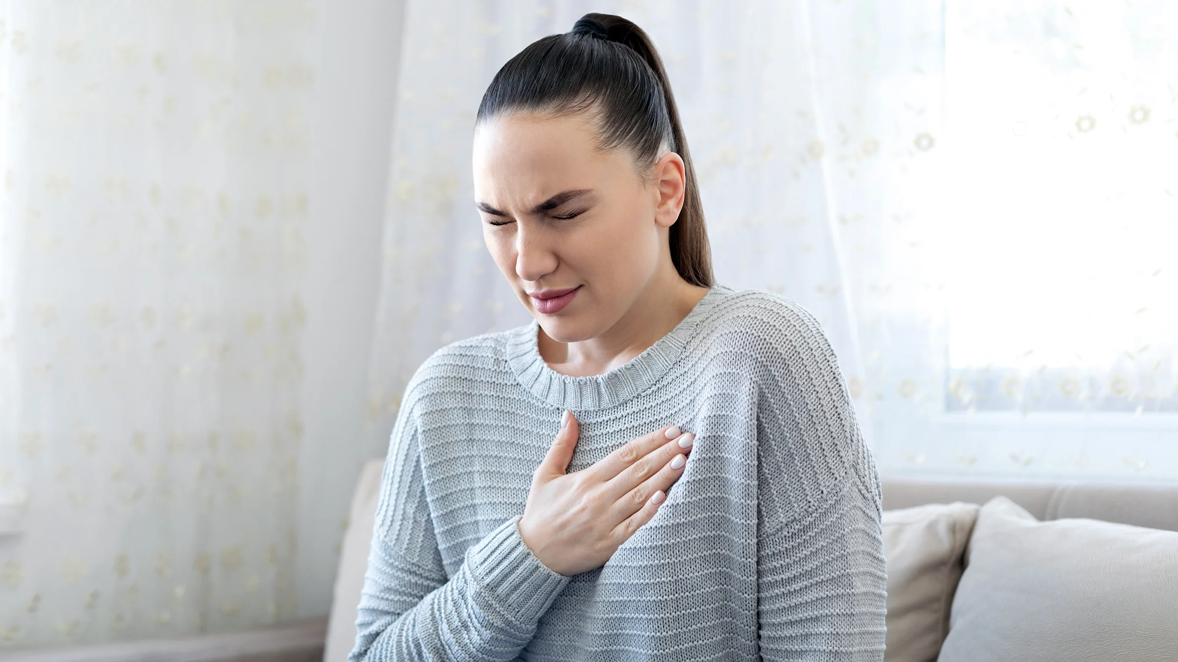 A woman struggles with heartburn.
