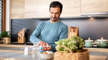 Health: Benazepril: man taking medicine in kitchen 1473708401