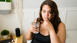 A nervous person taking a pill in bed.
Antonio_Diaz/iStock via Getty Images Plus 