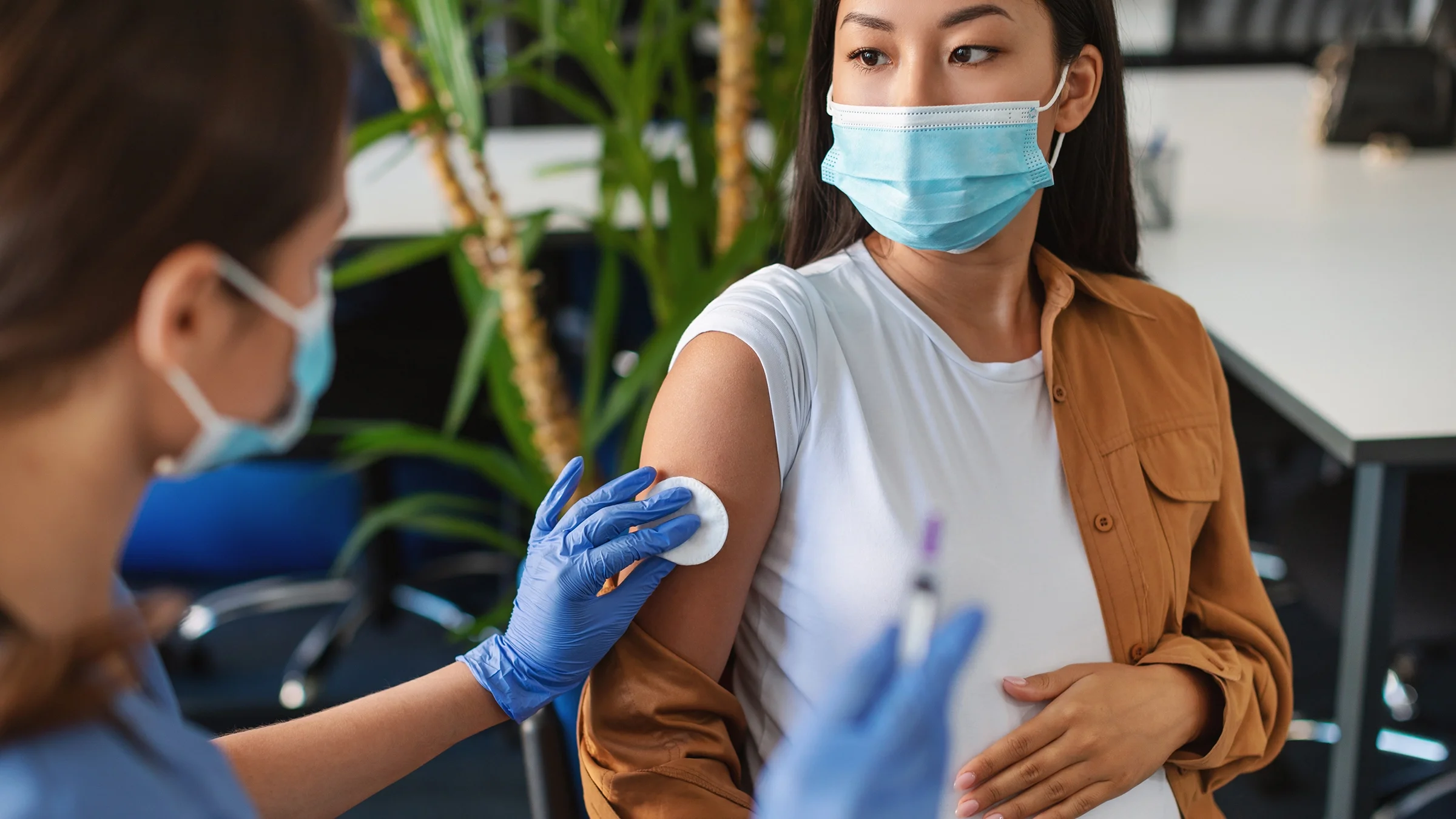 A pregnant woman receives a shot.