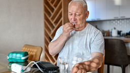 A man takes his medication after measuring his blood pressure.
AleksandarGeorgiev/E+ via Getty Images 
