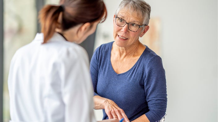 A woman speaks to a healthcare professional.