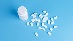 Pill bottle and pills on a blue background.
Oleh_Kucheriavyi/iStock via Getty Images 