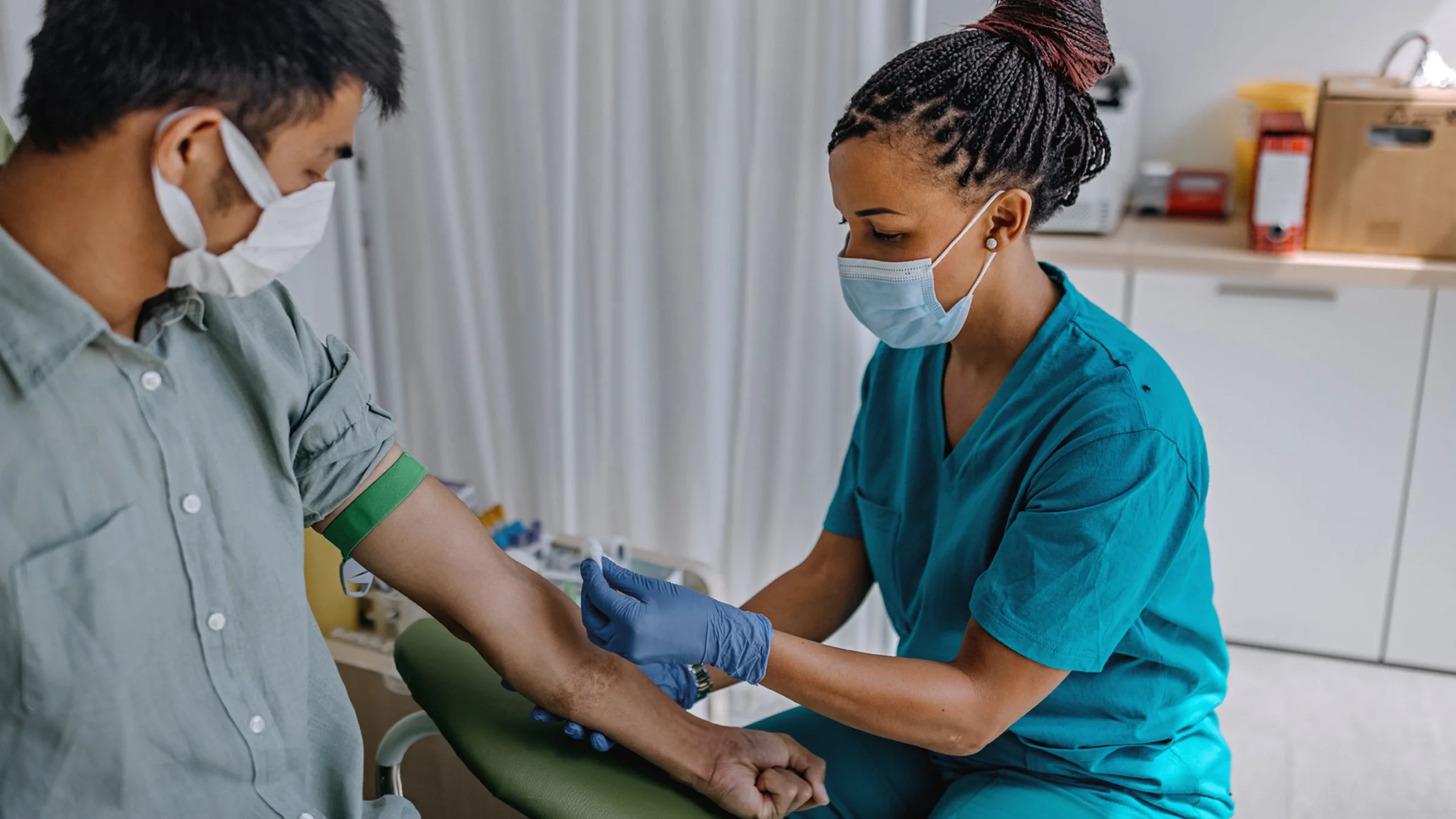 Patient at the lab getting his blood drawn by a phlebotomist.