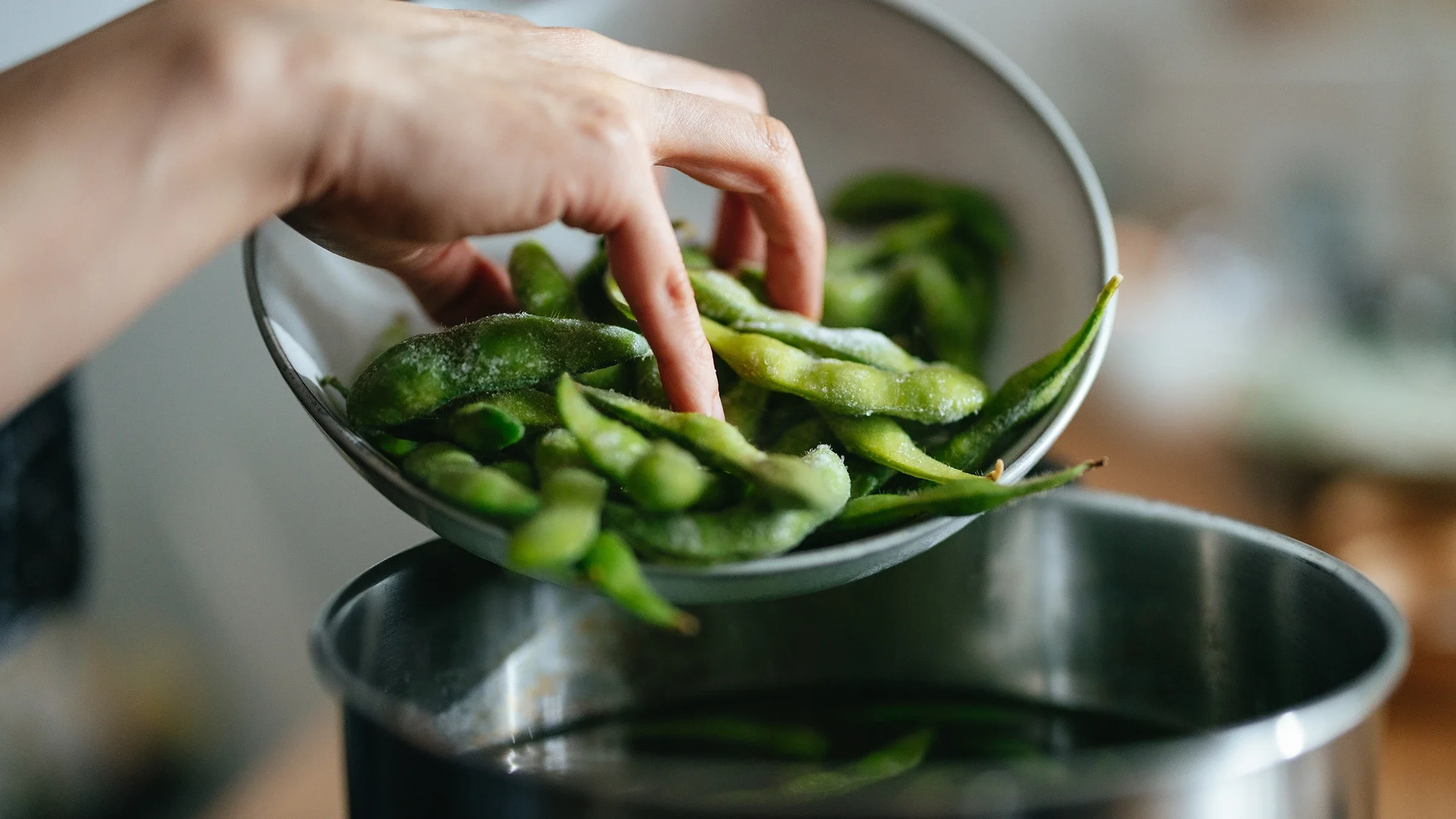 Edamame is transferred to a pot. 