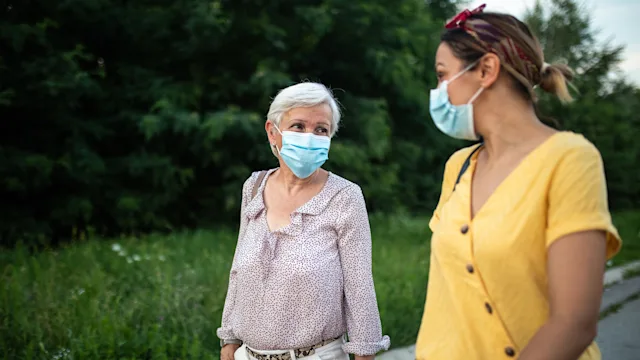 Vaccine: Hesitancy: masked conversation outside 1264500902