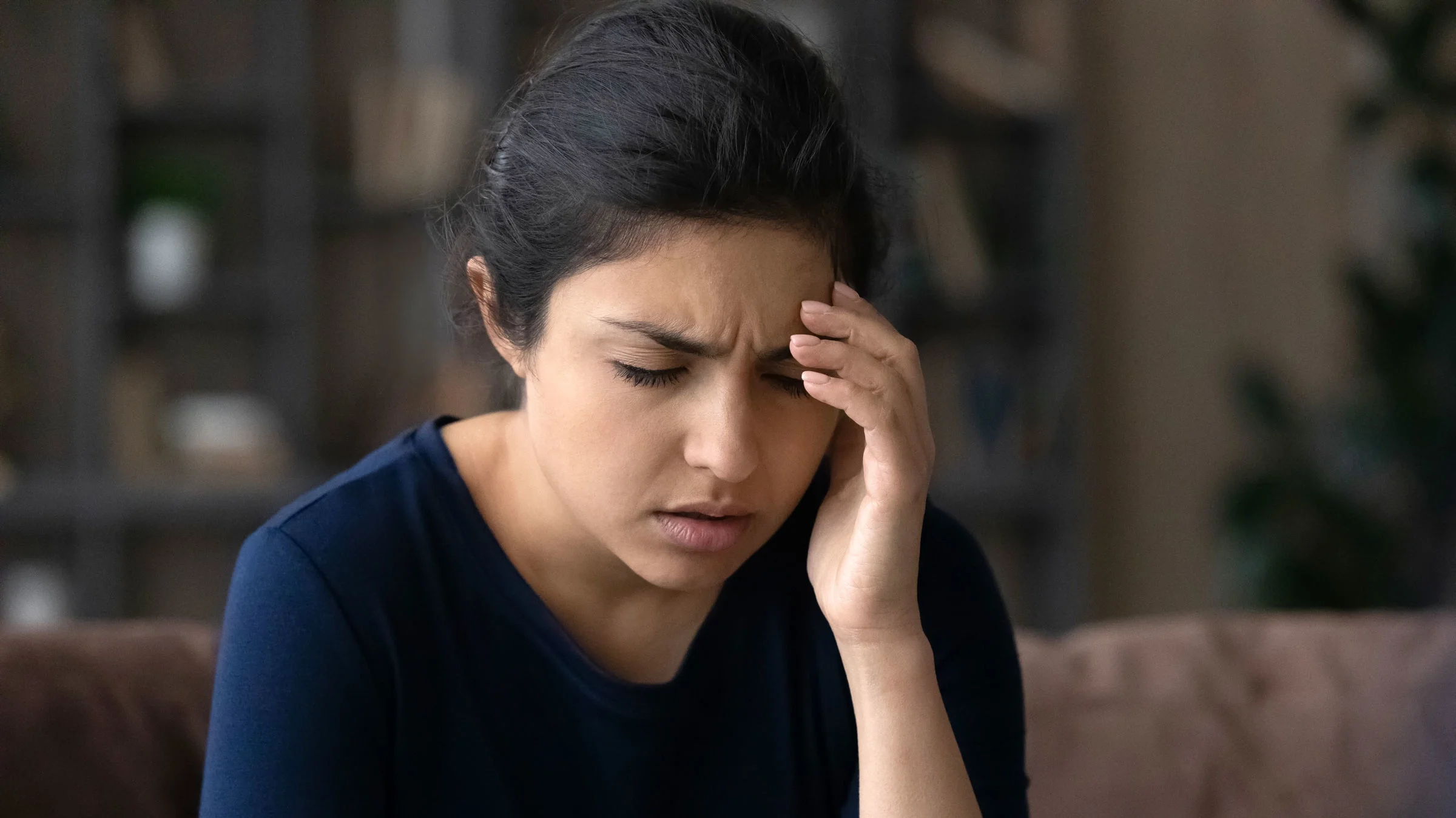 A woman is experiencing dizziness or blurry vision.