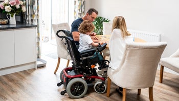 Muscular dystrophy: child in wheelchair doing a puzzle 1041472728