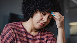A woman clutches her forehead as she suffers from a migraine.
Riska/E+ via Getty Images