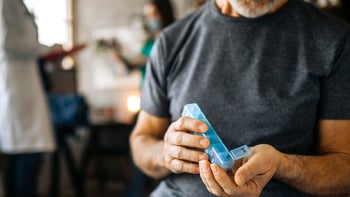 Side effects: closeup man with pill organizer 1293211998