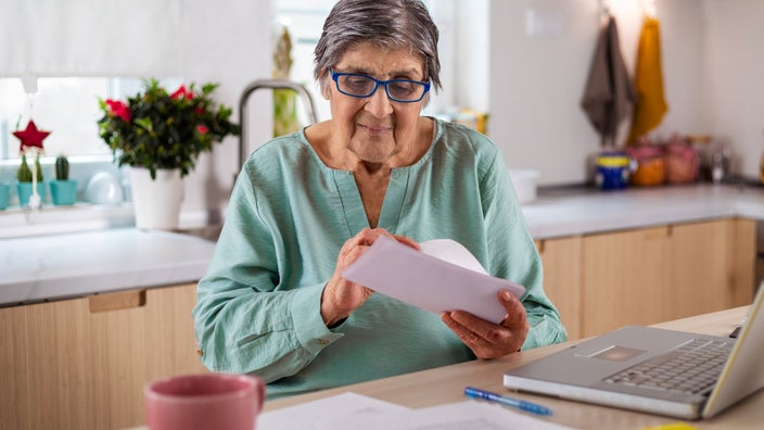 A senior adult calculating finances.
