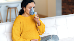 Portrait of a pregnant woman using an over the nose inhaler.
Kateryna Onyshchuk/iStock via Getty Images