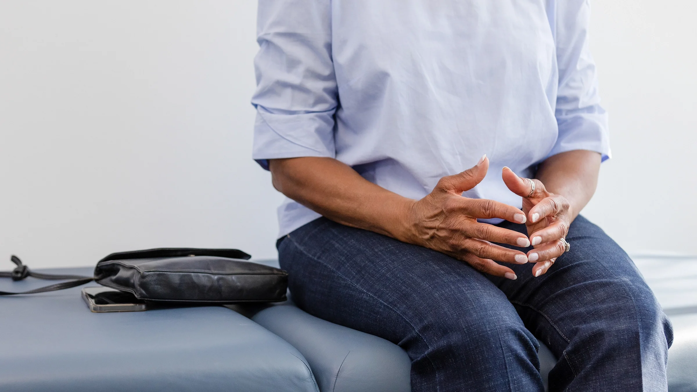 A woman waits on an examination table for her test results.