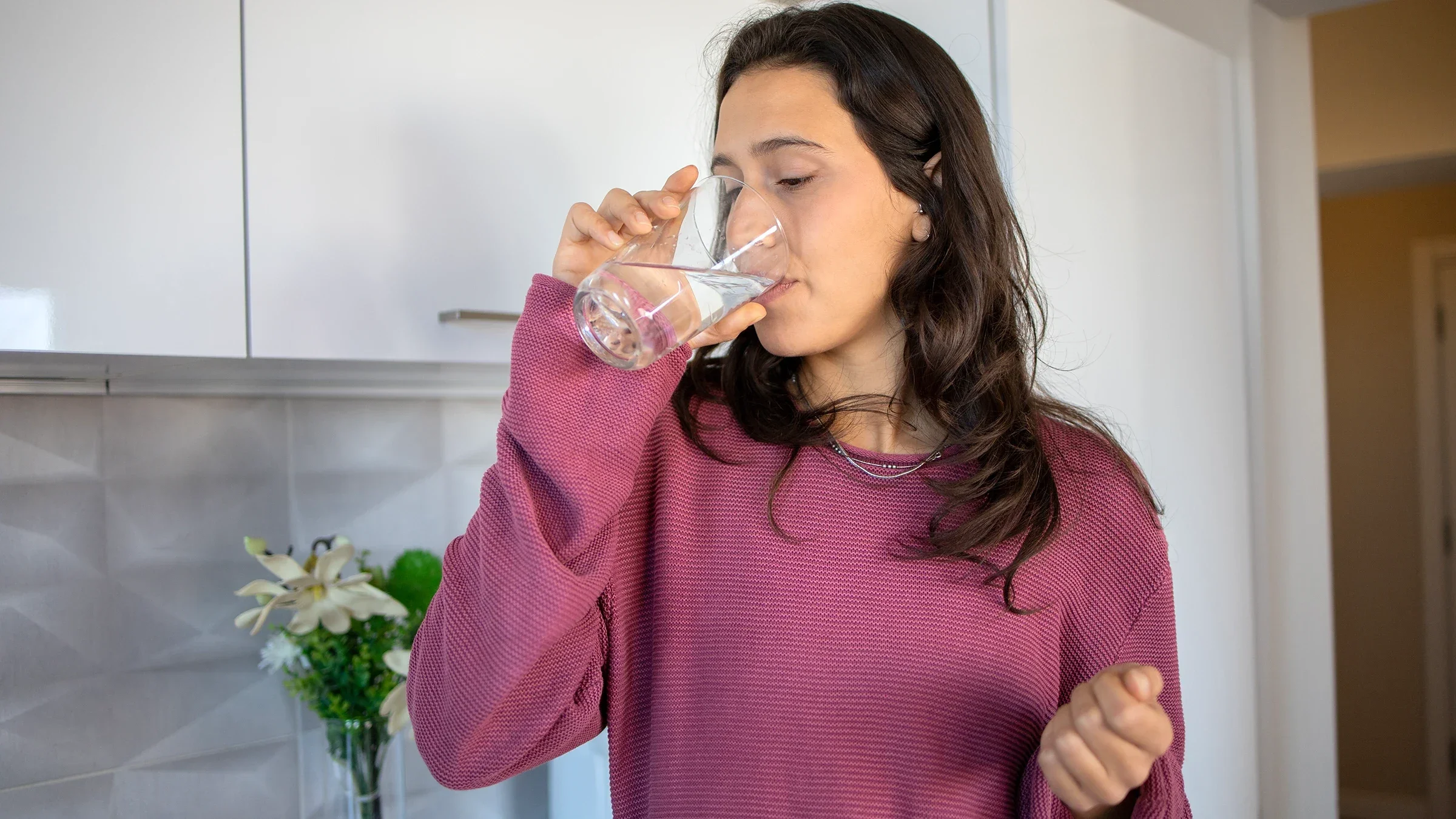 A woman is taking medication with a glass of water.
Rockaa/E+ via Getty Images