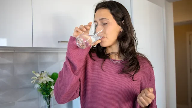 ingrezza: woman taking medication with water 1488476785