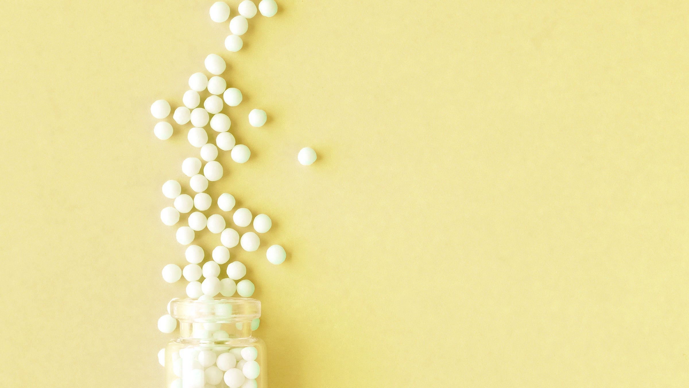 homeopathic pills yellow background 1157355819