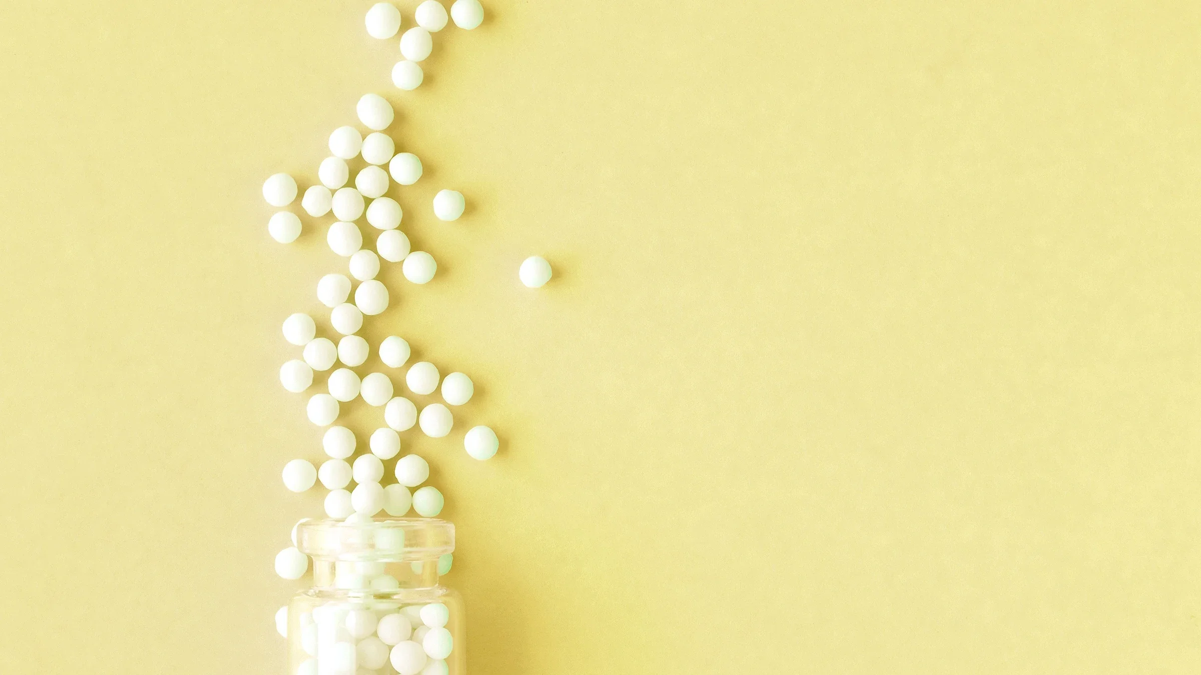 homeopathic pills yellow background 1157355819