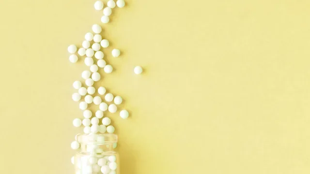 homeopathic pills yellow background 1157355819