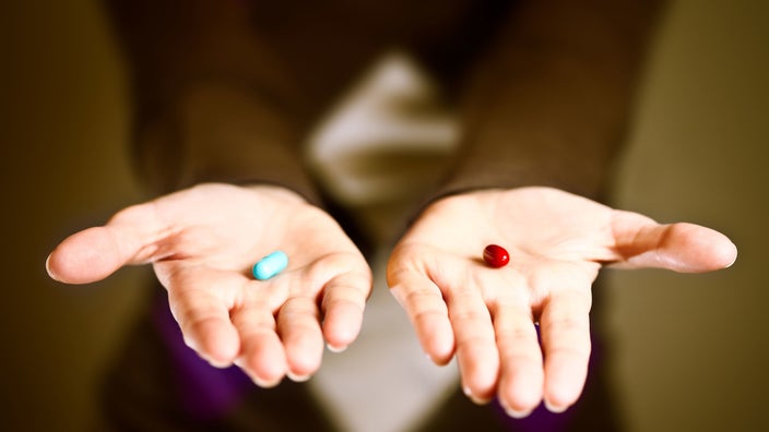 Woman holding pills in palm of hands.