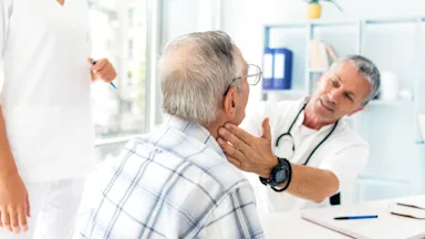 A doctor checking a patient's thyroid.
dardespot/E+ via Getty Images