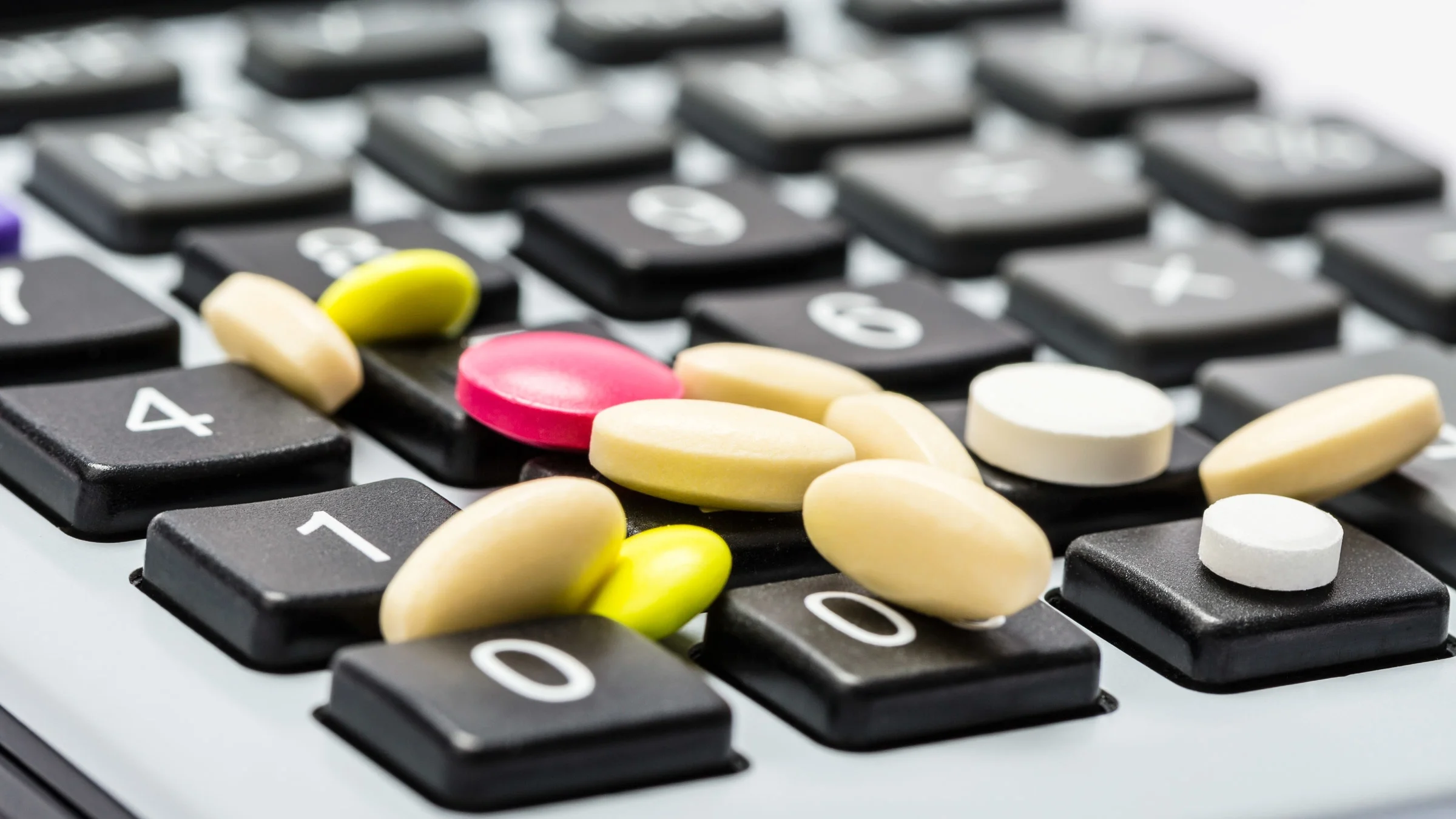 Colorful pills on top of a calculator.