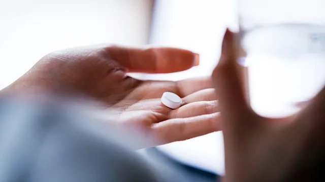 Aspirin: closeup pill water hand 1155911468