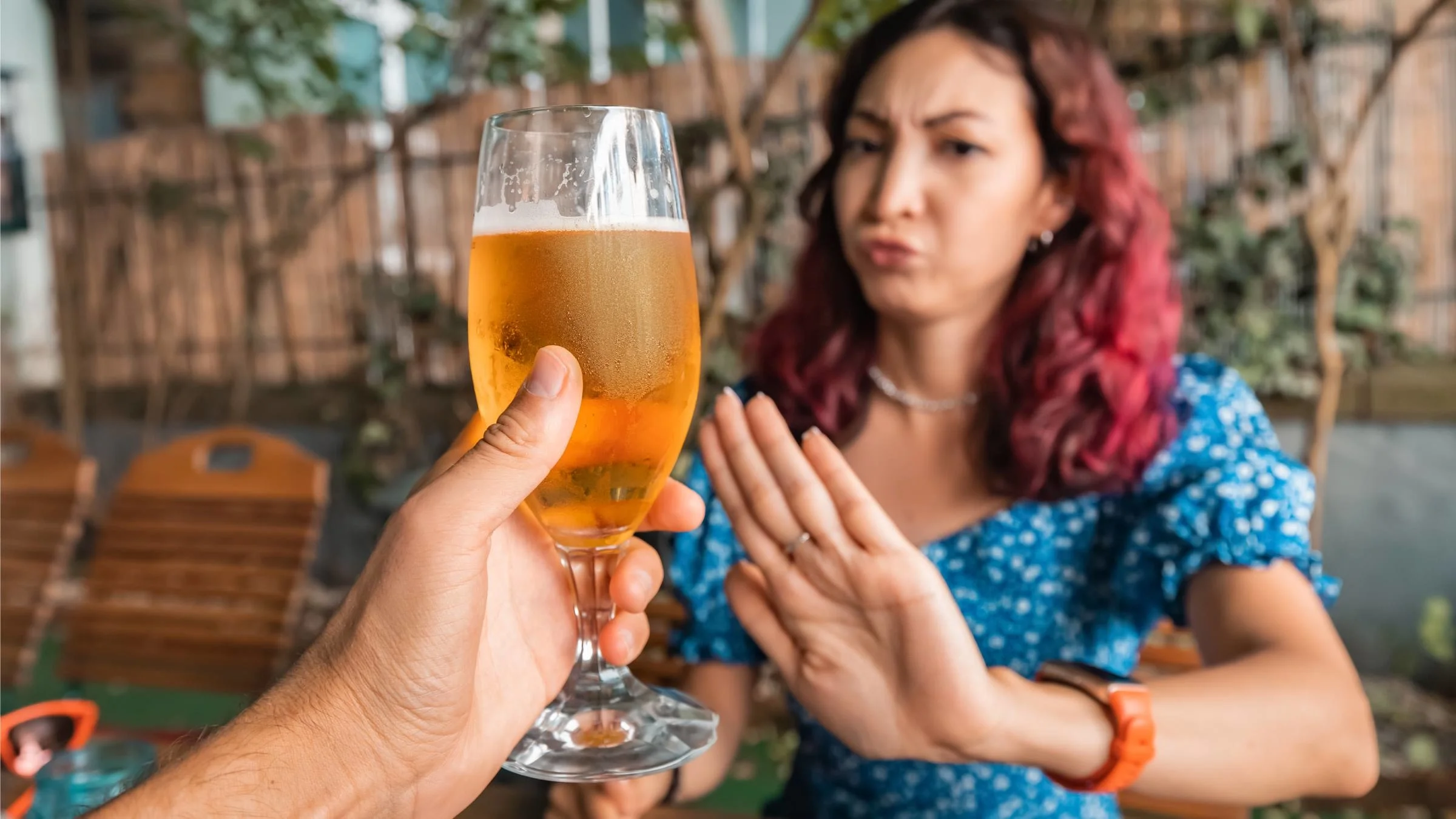A person turning down beer being offered to them.