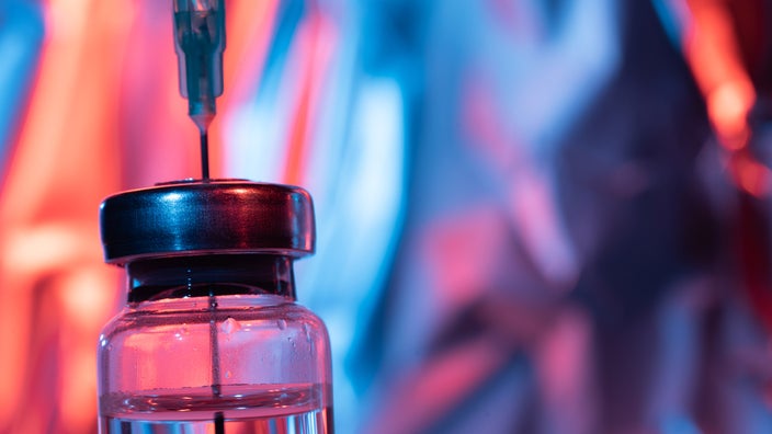 A close-up of a vaccine vial and needle.