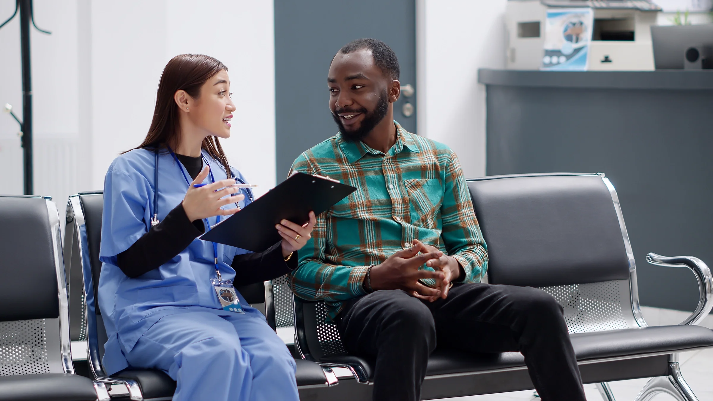 A healthcare professional is consulting with a male patient in a medical clinic.