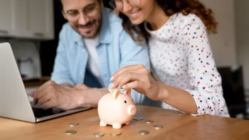 Chantix: couple places money in piggy bank-1320551776