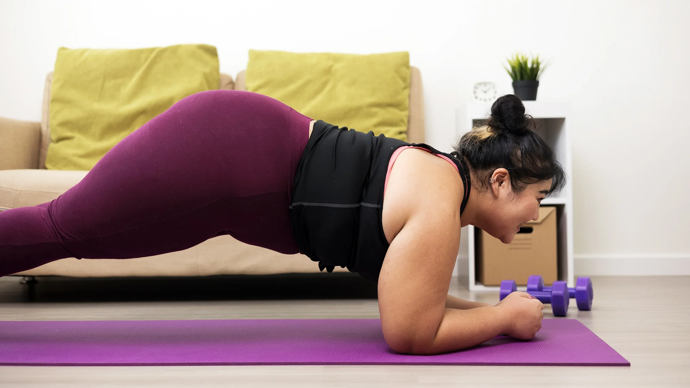 Woman doing forearm plank exercise at home.