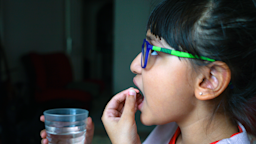 Child with glasses takes a pill with water.
Beyhes Evren/iStock via Getty Images Plus