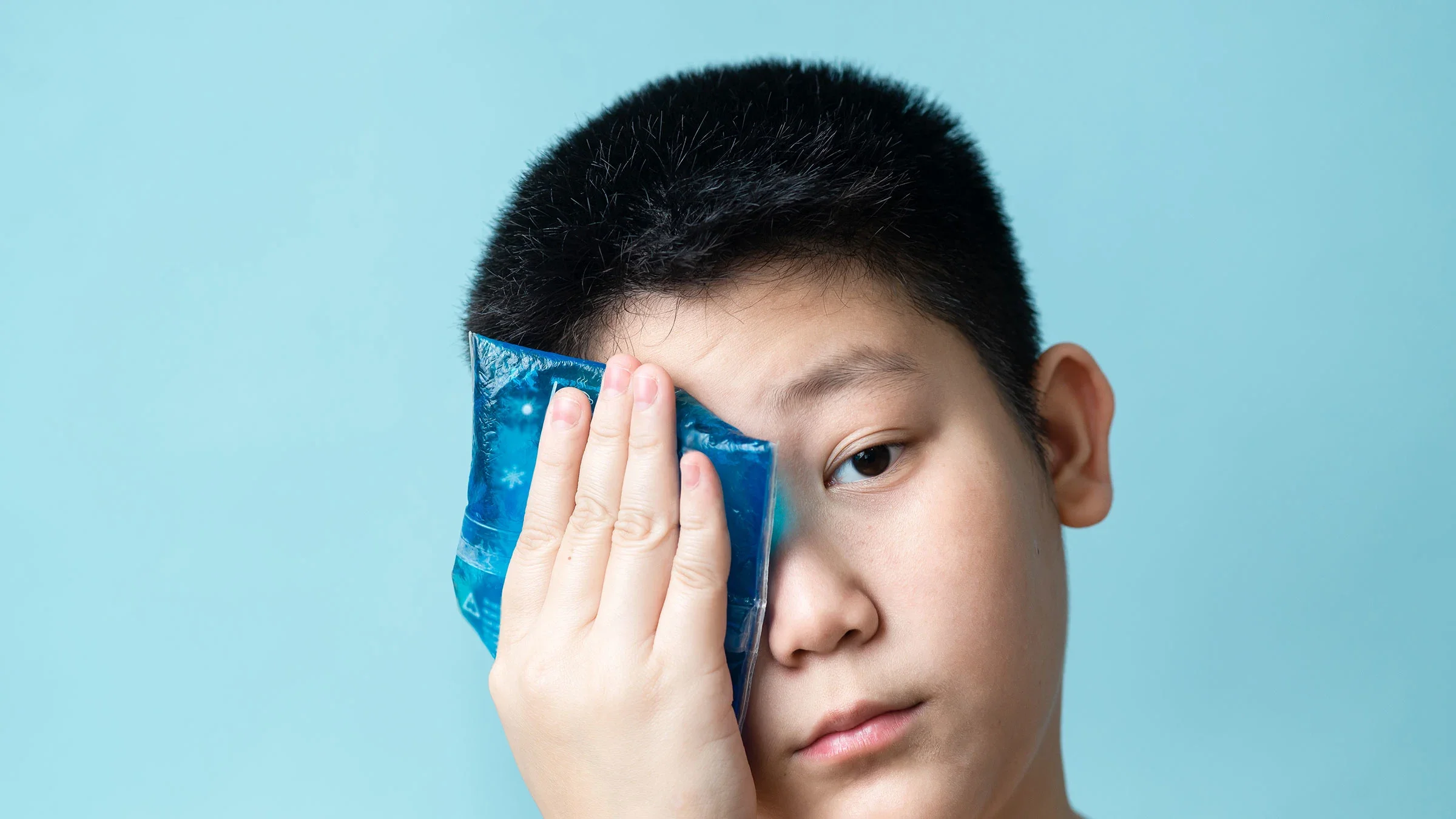 A child with pink eye uses a cool compress on an eye.
nuiiko/iStock via Getty Images Plus