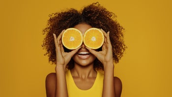 Health: Vitamin C: woman curly hair orange halves on eyes-1287400799