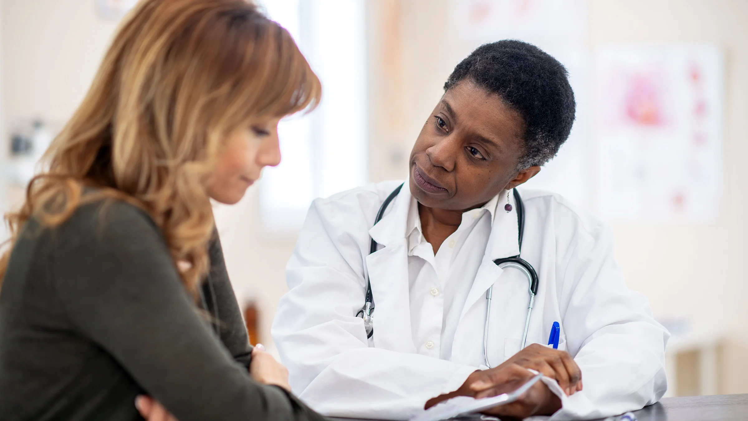 A woman speaks with a doctor during an appointment.